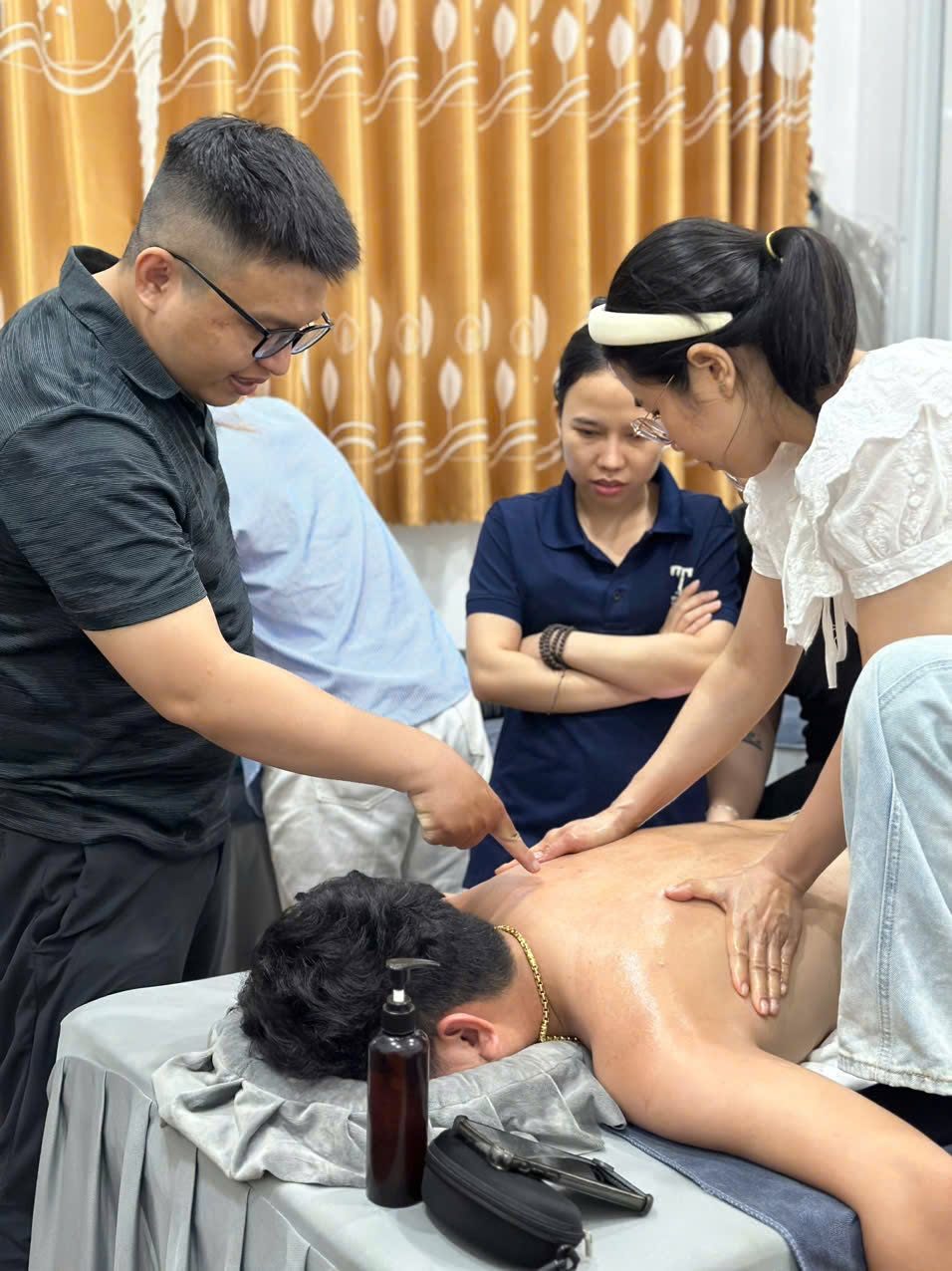 Giảng viên chỉnh động tác massage cho học viên